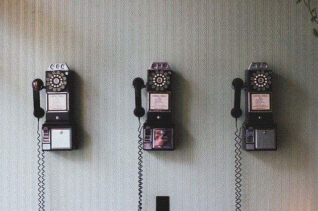 Three cute, pastel colored, old-fashion rotary telephones lined up next to each other hanging on the wall. Indicating that I would love to talk to you and I am looking forward to learning more about how I can fulfill your business needs.